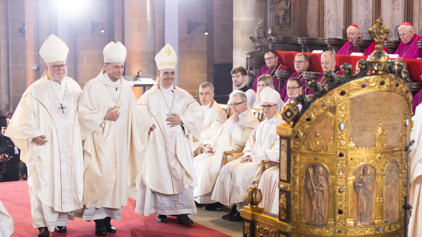 Herwig Gössl wird von Erzbischof Kardinal Dr. Reinhard Marx (links) und dem Apostolischen Nuntius Erzbischof Dr. Nikola Eterović zum Bischofsstuhl geführt © Pressestelle Erzbistum Bamberg / Dominik Schreiner