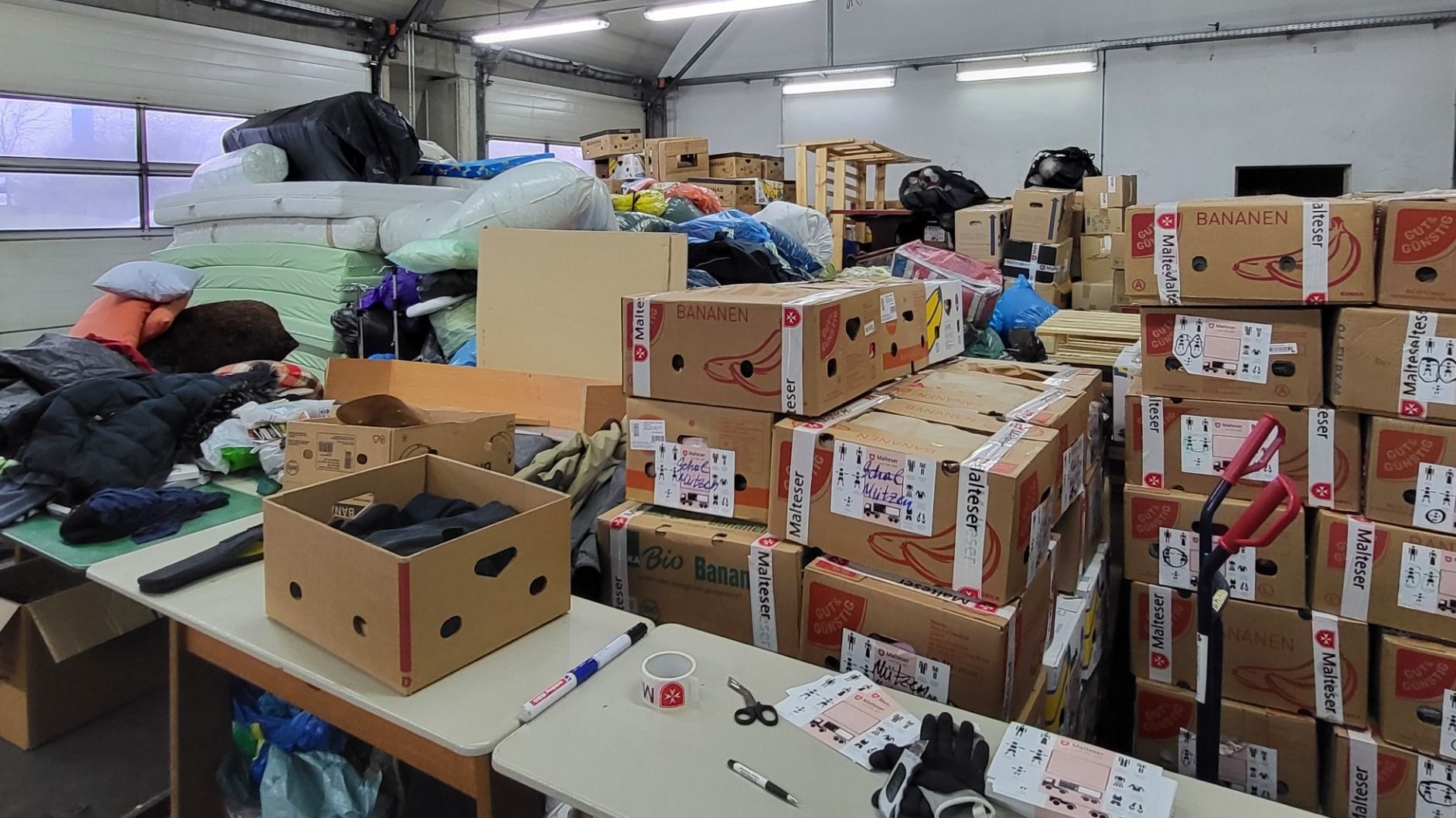 Die Halle der Malteser in der Breitunger Straße in Petersberg ist voll mit Kisten und Taschen voll warmer Bekleidung und weiteren Utensilien für die Ukraine. 